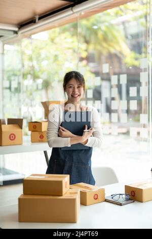 Porträt einer asiatischen jungen Frau KMU, die zu Hause mit einer Box arbeitet der Arbeitsplatz.Start-up Kleinunternehmer, Kleinunternehmer KMU oder Freiberufler Stockfoto