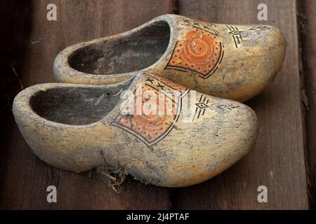 Zwei alte schmutzige traditionelle holländische Holzschuhe auf dem Boden Stockfoto