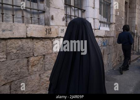 Ein Mitglied der sogenannten Haredi Burqa Sekte, auch bekannt als "Shawl Women" (jüdische religiöse Gruppe, in der ultra-orthodoxe jüdische Frauen behaupten, dass Bescheidenheit eine burka-artige Abdeckung des gesamten Körpers erfordert), geht durch Mea Shearim, ein ultra-orthodoxes Viertel in West-Jerusalem, Israel. Die Shalim, allgemein bekannt als der "Burka-Kult", ist eine der isoliertesten und verunglimpftesten Sekten in Israel, selbst unter der ultra-orthodoxen Bevölkerung des Landes. Stockfoto