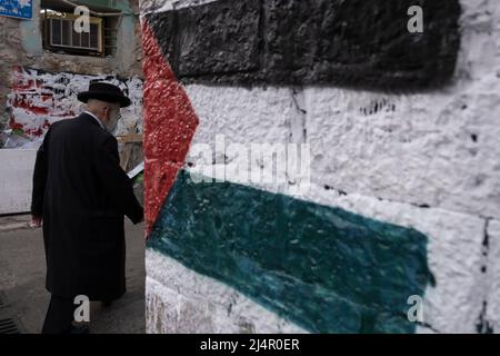 Ein orthodoxer Jude kommt an einer palästinensischen Flagge vorbei, die von extremen antizionistischen Haredi-Juden in Mea Shearim, einer ultra-orthodoxen Enklave in West-Jerusalem Israel, auf eine Wand gesprüht wurde Stockfoto