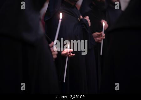 Mitglieder der armenisch-apostolischen Kirche halten Kerzen, während sie an einem Gottesdienst in der Grabeskirche in der Altstadt von Jerusalem in Israel teilnehmen Stockfoto