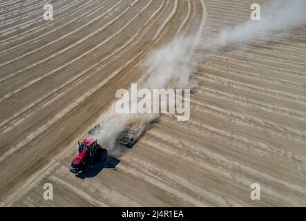Urumqi. 16. April 2022. Luftaufnahme vom 16. April 2022 zeigt einen Traktor, der in einem Baumwollfeld in Daquan in der Stadt Shawan, nordwestlich der Autonomen Region Xinjiang Uygur, arbeitet. Quelle: Hu Huhu/Xinhua/Alamy Live News Stockfoto