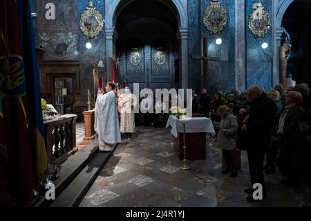 Lviv, Lviv, Ukraine. 17. April 2022. Menschen, die während der Zeremonie gesehen wurden. Die Bewohner von Lemberg feiern die Liturgie des katholischen Osterfestes in der Garnisonkirche St. Peter und Paul (ehemalige Jesuitenkirche) in der westlichen Stadt Lemberg, inmitten der Gefahr von Luftangriffen. (Bild: © Valeria Ferraro/ZUMA Press Wire) Bild: ZUMA Press, Inc./Alamy Live News Stockfoto