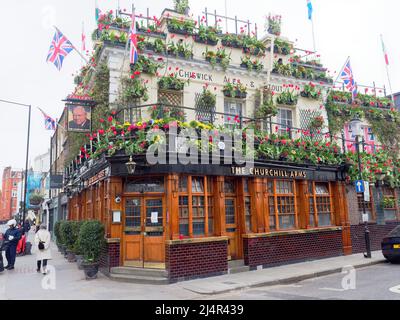 Der Blick auf die Churchill Arms in Notting Hill ist aufgrund seiner Blumenpracht oft als Londons buntestes Pub bekannt Stockfoto