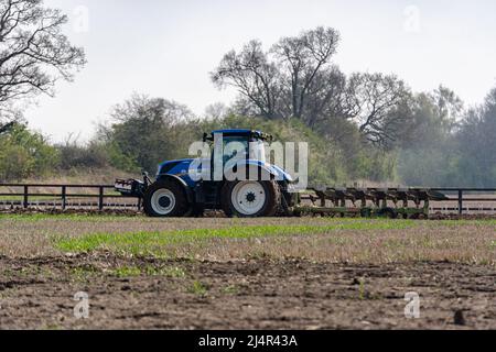 Woodbridge Suffolk UK April 15 2022: Traktor pflügt die Felder in der Landschaft von Suffolk zur Vorbereitung auf die Pflanzung von Pflanzen Stockfoto