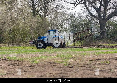 Woodbridge Suffolk UK April 15 2022: Traktor pflügt die Felder in der Landschaft von Suffolk zur Vorbereitung auf die Pflanzung von Pflanzen Stockfoto