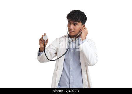 Porträt eines jungen peruanischen männlichen Arztes, der das Stethoskop benutzt, isoliert. Stockfoto