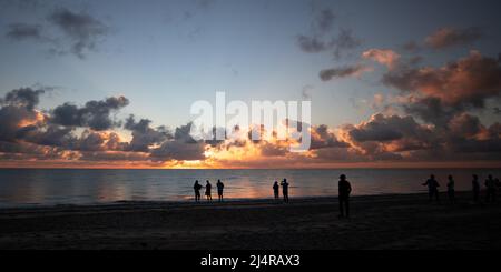 Die Menschen beobachten den Sonnenaufgang am Strand in Delray Beach, Florida. Stockfoto