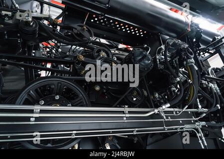 Harvester-Motor, Getriebe-Ketten, Mechanismen Übertragung der neuen modernen Technologie kombinieren Fahrzeugmotor mit Metall, Kunststoffteile, Antriebsriemen, schwere landwirtschaftliche Industrie Ausrüstung. Stockfoto