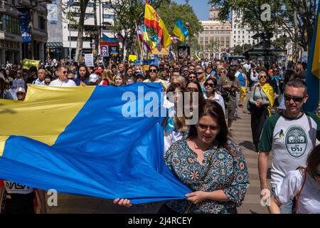 Barcelona, Spanien. 17. April 2022. Demonstranten halten während der Demonstration eine riesige ukrainische Flagge, während sie durch die Straße marschieren. Hunderte von Ukrainern mit Wohnsitz in Barcelona haben im Zentrum von Barcelona demonstriert, um ihre Unterstützung für den Widerstand der ukrainischen Bevölkerung zu zeigen. Kredit: SOPA Images Limited/Alamy Live Nachrichten Stockfoto