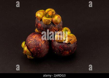 Mangostan isoliert auf schwarzem Hintergrund. Aufgenommen in Studiobeleuchtung. Aufnahme von braunem Mangostan auf weißem Hintergrund. Thailändische Mangostan Schießen Auf Weiß. Stockfoto