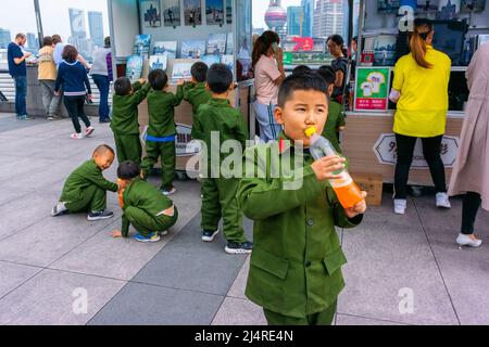 Shanghai, China, Straßenszene, Große Gruppe. Menschen, chinesische Touristen, Kinder in Militäruniformen, Besuch des Bundes, im Stadtzentrum, china Militär, Studenten draußen, Street Boys, china-Kleinkinder, alkoholfreie Getränke, Kind, shanghai-Bund Stockfoto