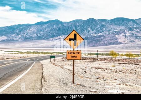 Straßenschild im Death Valley USA an der Wüstenkreuzung - Badwater Road mit Sierra Nevada Mountains in der Ferne. Stockfoto