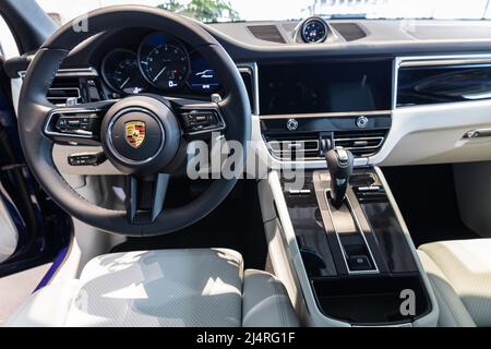 Porsche Macan Interior - ein Lenkrad mit Knöpfen, Armaturenbrett, Tachometer und Schaltgriff des Getriebes Stockfoto