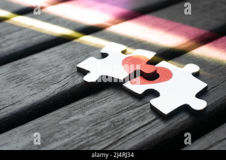 Rotes Herz ist auf die Stücke der Holzpuzzle nebeneinander liegend auf Holz- Hintergrund dargestellt. Liebe Konzept. St. Valentinstag Stockfoto