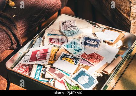 Bild einer Sammlung alter Briefmarken in einer alten Zigarrenbox. Stockfoto