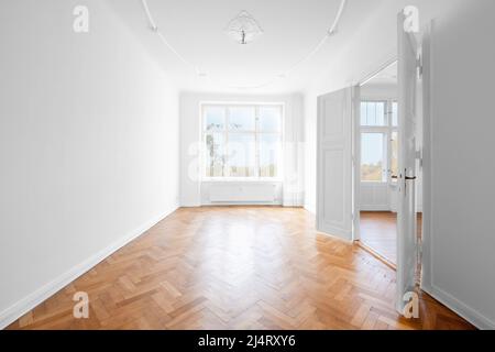 Neues, leeres Apartment-Zimmer mit Holzparkettboden Stockfoto