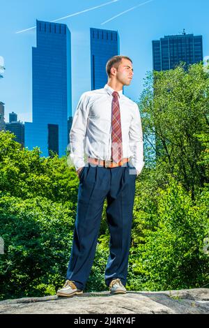 Aufstehen, Weit Schauen. Trägt ein weißes Langarmshirt, eine schwarze Hose, eine Musterbinde, einen kurzen Haarschnitt, einen jungen Profi, der vorne steht Stockfoto