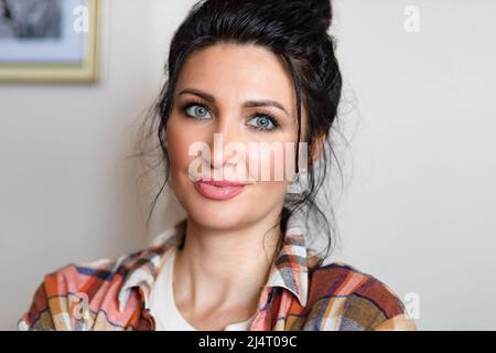 Nahaufnahme einer blauäugigen, brünetten Frau mittleren Alters Stockfoto