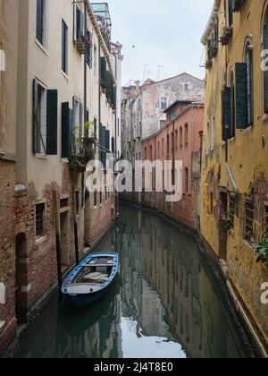 Kanal im Stil einer Seitenstraße in Venedig, der am frühen Morgen ruhig wartet, bevor der Verkehr beginnt. März 2022. Stockfoto