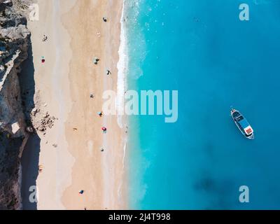 Direkt über dem Blick auf den strand von egremni auf der Insel Lefkada, Griechenland Copy Space kleines Kreuzfahrtboot Stockfoto