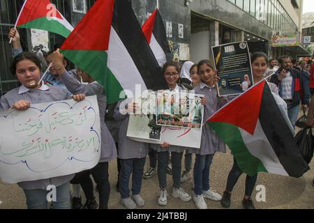 Nablus, Palästina. 17. April 2022. Palästinensische Kinder winken Flaggen und tragen Bilder ihrer Verwandten, die während der Demonstration in israelischen Gefängnissen inhaftiert sind. Palästinensische Kundgebung anlässlich des Palästinensischen Gefangenentags (an dem die Palästinenser sich ihrer in israelischen Gefängnissen inhaftierten Freunde und Familienmitglieder gedenken), in der die Freilassung palästinensischer Häftlinge in israelischen Besatzungsgefängnissen gefordert wird. Kredit: SOPA Images Limited/Alamy Live Nachrichten Stockfoto