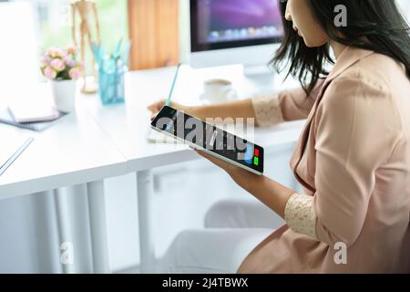 Finanz- und Investitionsplanungskonzept, weibliche Geschäftsfrau mit Computer, um Charts zu analysieren, um Einstiegspunkte auf einem Trading Board zu finden. Durch Stockfoto