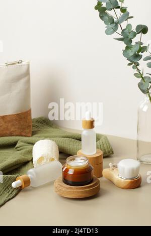 Set von NATÜRLICHEN Bio-Kosmetikprodukten SPA. Glas mit Feuchtigkeitscreme auf Holzplattform, Glasflaschen, Körperbürste, Loofah. Eco Beauty-Produkte Stockfoto