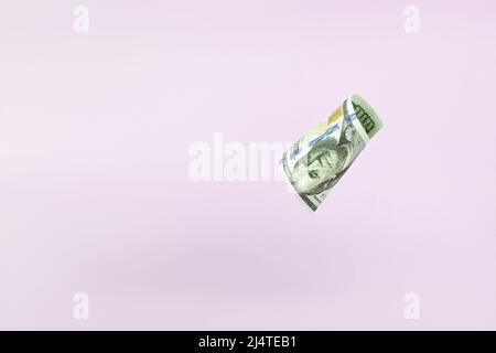 Fliegende 100-Dollar-Rechnungen auf pastellfarbenem Hintergrund. US 100-Dollar-Schein aus nächster Nähe. Stockfoto