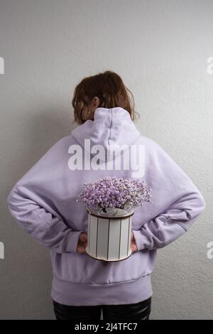 Schachtel mit rosa Blumen für Babys Atem. Geschenkblumen in weißer Schachtel. Frau, die eine Blumenkachtel mit Gypsophila hält. Stockfoto