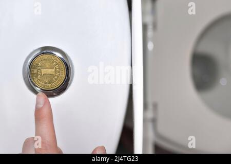 Wasserhähne im Badezimmer mit einer ukrainischen Griwna-Münze, Übersetzung aus dem Ukrainischen: Eine Griwna, ukraine. Stockfoto