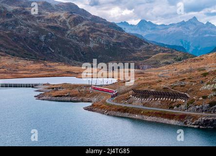 Berninapass, Schweiz - 19. Januar 2022: BERNINA Express Panorama-Touristenzug fährt zwischen Chur und Tirano in Italien und überquert Schnee-Cov Stockfoto