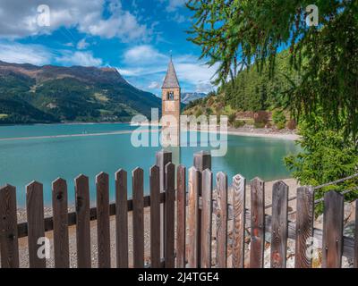 Der Glockenturm der Kirche stammt aus dem überfluteten Dorf Graun - Curon im Vinschgau, Südtirol, Italien Stockfoto