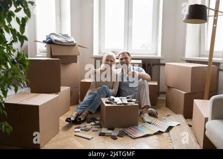 Glückliche ältere Ehepartner zeigen Schlüssel aus dem neuen Haus Stockfoto