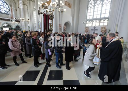 Lviv, Ukraine. 17. April 2022. Ukrainische Gläubige erhalten heilige Kommunion, während sie Palmsonntag inmitten der russischen Invasion feiern. Der Palmsonntag ist der erste Tag der Karwoche und der Sonntag vor Ostern, der an den Eintritt Jesu Christi in Jerusalem erinnert. Kredit: SOPA Images Limited/Alamy Live Nachrichten Stockfoto