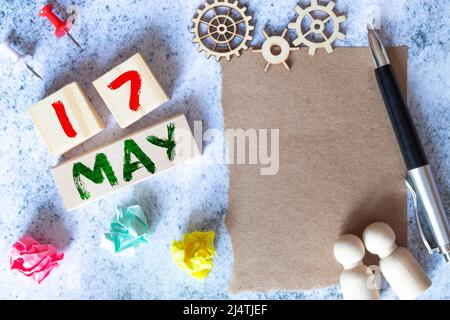 Holzkalender mit Datum 17. Mai und Staffelei auf blauem Hintergrund, Ort für Text, Welttag der Telekommunikation und Informationsgesellschaft Welthypertension Stockfoto
