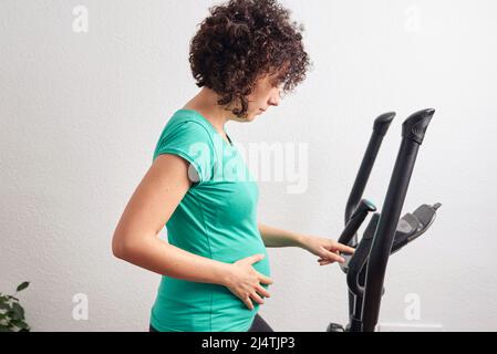 Schwangere Frau Training zu Hause Stockfoto