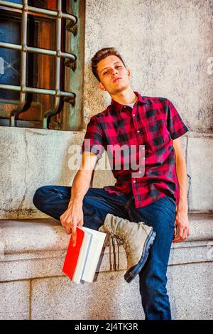 Mann, Der Sich Draußen Entspannt. Kleid in einem kurzen Ärmel, schwarz, rot gemustertes Hemd, Jeans, Stiefel Schuhe, Ein junger, gutaussehender Kerl sitzt an einem Fenster, Kopf lea Stockfoto