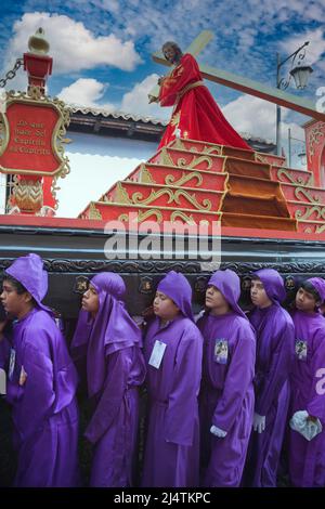 Antigua, Guatemala. Jugendliche Jungen, die während der Karwoche einen Schwimmer in einer religiösen Prozession tragen, La Semana Santa. Stockfoto