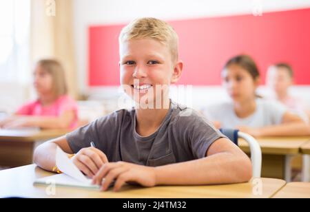 Lächelnd fleißig präteen Junge studieren mit Klassenkameraden Stockfoto