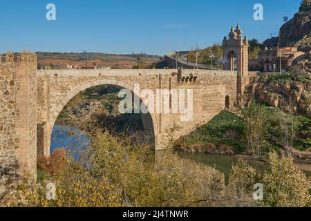 Römische Brücke von Alcantara über dem Fluss Tejo aus dem 3.. Jahrhundert. Berühmtes Denkmal von Toledo. Das Hotel liegt am Fuße des Schlosses von San Servando. Stockfoto