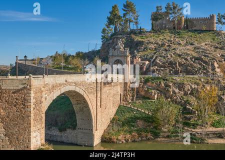 Römische Brücke von Alcantara über dem Fluss Tejo aus dem 3.. Jahrhundert. Berühmtes Denkmal von Toledo. Das Hotel liegt am Fuße des Schlosses von San Servando. Stockfoto