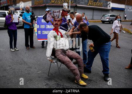 CARACAS, VENEZUELA - 17. APRIL: Gegner der Regierung des venezolanischen Präsidenten Nicolás Maduro verbrennen eine Schaufensterpuppe mit den Bildern von Maduro (C-Boden), Der russische Präsident Wladimir Putin (C-Top) und die Bürgermeisterin von Caracas, Carmen Meléndez (L), während der traditionellen „Verbrennung von Judas“ im Inneren im Rahmen der Karwoche in La Candelaria am 17. April 2022 in Caracas, Venezuela. (Foto von Pedro Rances Mattey/PxImages) Credit: Px Images/Alamy Live News Stockfoto