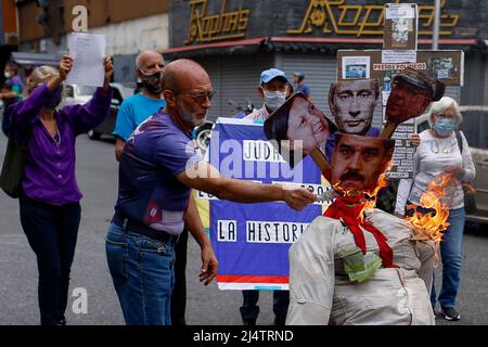 CARACAS, VENEZUELA - 17. APRIL: Gegner der Regierung des venezolanischen Präsidenten Nicolás Maduro verbrennen eine Schaufensterpuppe mit den Bildern von Maduro (C-Boden), Der russische Präsident Wladimir Putin (C-Top) und die Bürgermeisterin von Caracas, Carmen Meléndez (L), während der traditionellen „Verbrennung von Judas“ im Inneren im Rahmen der Karwoche in La Candelaria am 17. April 2022 in Caracas, Venezuela. (Foto von Pedro Rances Mattey/PxImages) Credit: Px Images/Alamy Live News Stockfoto