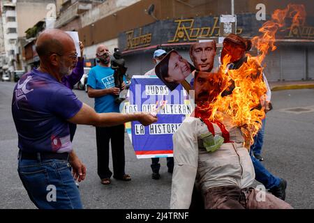 CARACAS, VENEZUELA - 17. APRIL: Gegner der Regierung des venezolanischen Präsidenten Nicolás Maduro verbrennen eine Schaufensterpuppe mit den Bildern von Maduro (C-Boden), Der russische Präsident Wladimir Putin (C-Top) und die Bürgermeisterin von Caracas, Carmen Meléndez (L), während der traditionellen „Verbrennung von Judas“ im Inneren im Rahmen der Karwoche in La Candelaria am 17. April 2022 in Caracas, Venezuela. (Foto von Pedro Rances Mattey/PxImages) Credit: Px Images/Alamy Live News Stockfoto