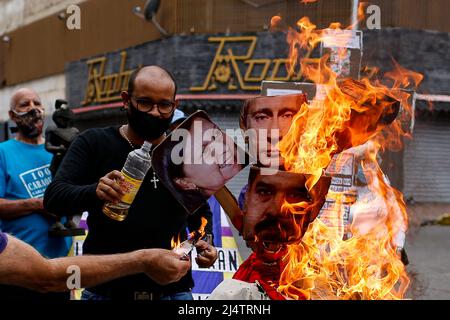 CARACAS, VENEZUELA - 17. APRIL: Gegner der Regierung des venezolanischen Präsidenten Nicolás Maduro verbrennen eine Schaufensterpuppe mit den Bildern von Maduro (C-Boden), Der russische Präsident Wladimir Putin (C-Top) und die Bürgermeisterin von Caracas, Carmen Meléndez (L), während der traditionellen „Verbrennung von Judas“ im Inneren im Rahmen der Karwoche in La Candelaria am 17. April 2022 in Caracas, Venezuela. (Foto von Pedro Rances Mattey/PxImages) Credit: Px Images/Alamy Live News Stockfoto