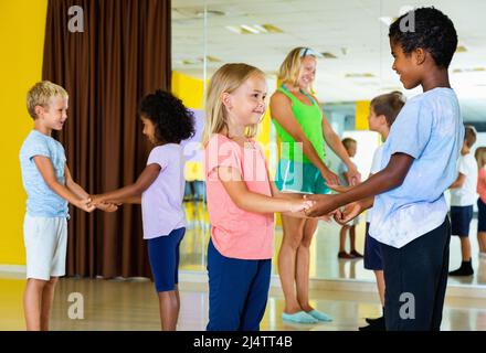 Gruppe von Kindern üben kräftige Jive-Bewegungen im Tanz cl Stockfoto