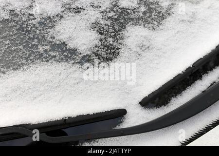 Nahaufnahme von Graupel Schneepellets auf einem Windschutz eines Fahrzeugs Stockfoto