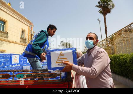 Kairo, Ägypten. 16. April 2022. Mitarbeiter entladen Ramadan-Geschenkboxen aus einem Fahrzeug während einer Ramadan-Wohltätigkeitsveranstaltung in Kairo, Ägypten, am 16. April 2022. Mehr als 30 chinesische Unternehmen in Ägypten haben die Chance auf eine Ramadan-Wohltätigkeitsveranstaltung in Kairo genutzt, um 1 Millionen ägyptische Pfund (etwa 54.245 US-Dollar) zu spenden, um Familien in Not zu helfen, sagten die Organisatoren am Samstag. Die diesjährige Veranstaltung ist die achte ihrer Art seit ihrer Gründung durch die Chinesische Handelskammer in Ägypten im Jahr 2015. Quelle: Sui Xiankai/Xinhua/Alamy Live News Stockfoto