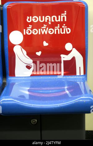 Sitzplätze auf dem BTS Skytrain in Bangkok, die vorschlagen, dass Sie den Platz für weniger fähige Personen auslassen, wobei Schwangeren und älteren Menschen vorgeschlagen wird Stockfoto